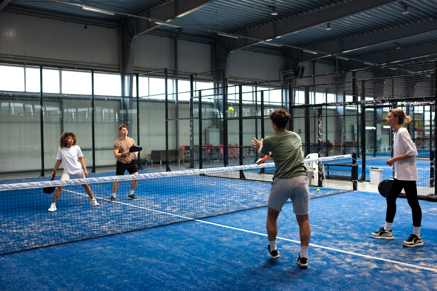 people playing paddle tennis in a sports facility indoors mobile medical corporation sports occupational industry health and wellness services